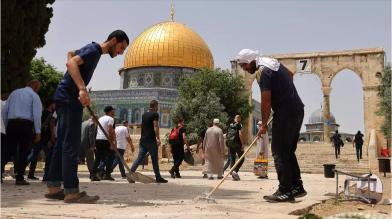 Des Palestiniens nettoient l'esplanade des Mosquées à Jérusalem, le 10 mai 2021, après de nouveaux affrontements avec des policiers israéliens. © Ahmad Gharabli, AFP