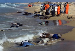 Des secouristes sur la plage d’al-Qarbole, où gisent des corps de migrants clandestins à 60 km à l’est de Tripoli, en Libye le 25 août 2014 | AFP