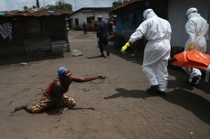 . Une femme dit ses adieux à sa soeur morte de la fievre Ebola (John Moore / Getty Images) . Une femme dit ses adieux à sa soeur morte de la fievre Ebola (John Moore / Getty Images)