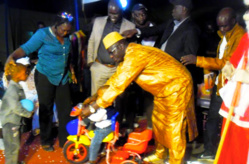 Le directeur Ibrahima DIAO remet un cadeau à un enfant du personnel, en présence de Masseck NGOM et Birima NDIAYE