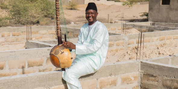 Ablaye Cissoko, ici en juin 2015 sur l'emplacement de sa future école de kora, près de Saint-Louis, au Sénégal. Crédits : Youri Lenquette