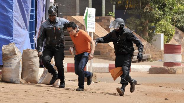 Un otage évacué de l'hôtel Radisson Blu par les forces de sécurité maliennes, à Bamako, le 20 novembre 2015.  (HABIBOU KOUYATE / ANADOLU AGENCY / AFP)