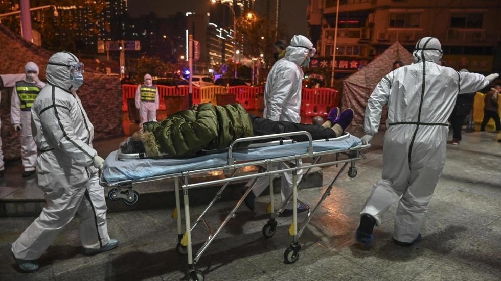 Des membres du personnel médical arrivent avec un patient à l'hôpital de la Croix-Rouge de Wuhan, le 25 janvier 2020. Hector RETAMAL / AFP