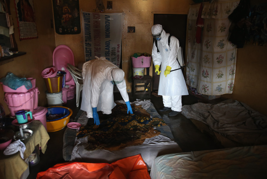 )   Une équipe de sépulture Ebola recueille le corps d'une fillette de quatre ans d'un appartement le 10 Octobre 2014 à Monrovia au Libéria. (John Moore / Getty Images)
