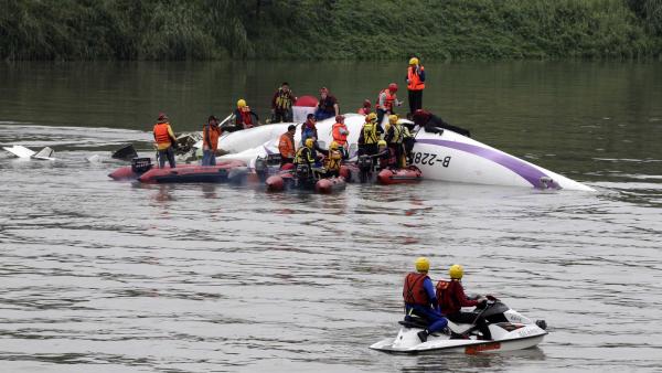 Les secours taïwanais tentent d'extirper les rescapés de la carcasse de l'avion de TransAsia qui s'est abîmé dans une rivière de Taipei le 4 février 2015 avec 58 personnes à bord.