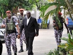 Le général Brunot Dogbo Blé (en costume) lors de son arrivée à son procès en 2014 à Abidjan. Il est l'un des 14 militaires proches de Gbagbo qui seront jugés pour les violences commises lors de la crise post-électorale de 2010-2011