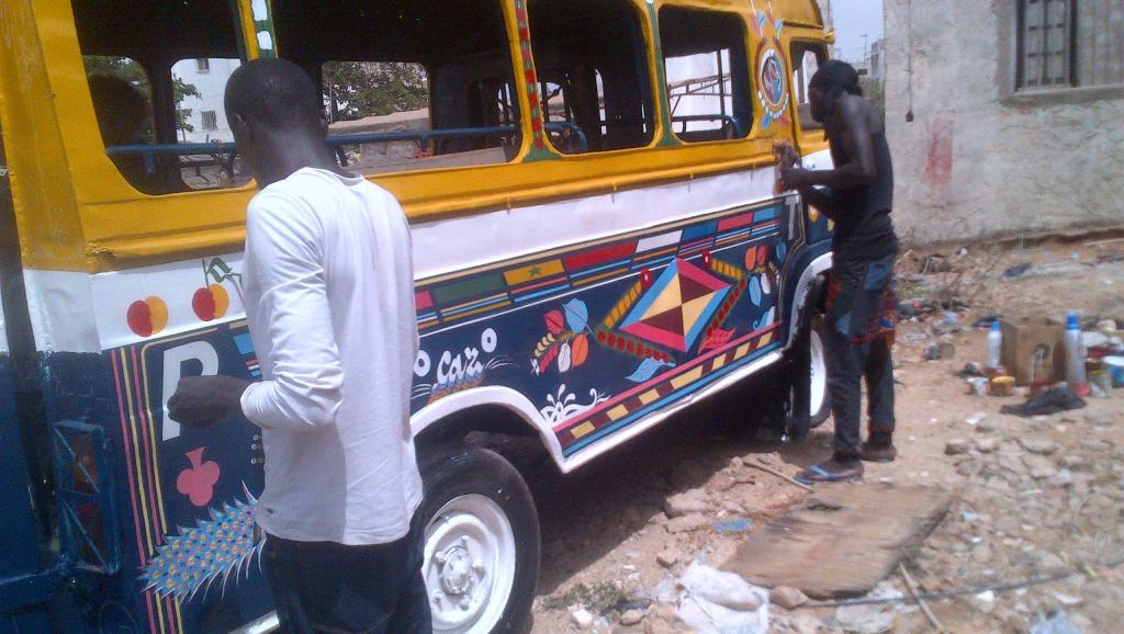 Sur le parking de la mairie de Liberté 3, à Dakar, un vieux car rapide en train d'être repeint.